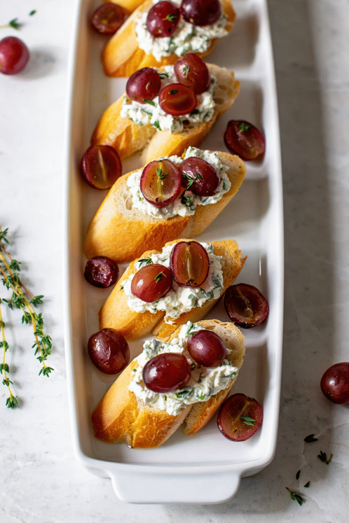 20 Christmas Party Appetizers That Will Steal the Show 11 Herbed Ricotta and Roasted Grape Crostini